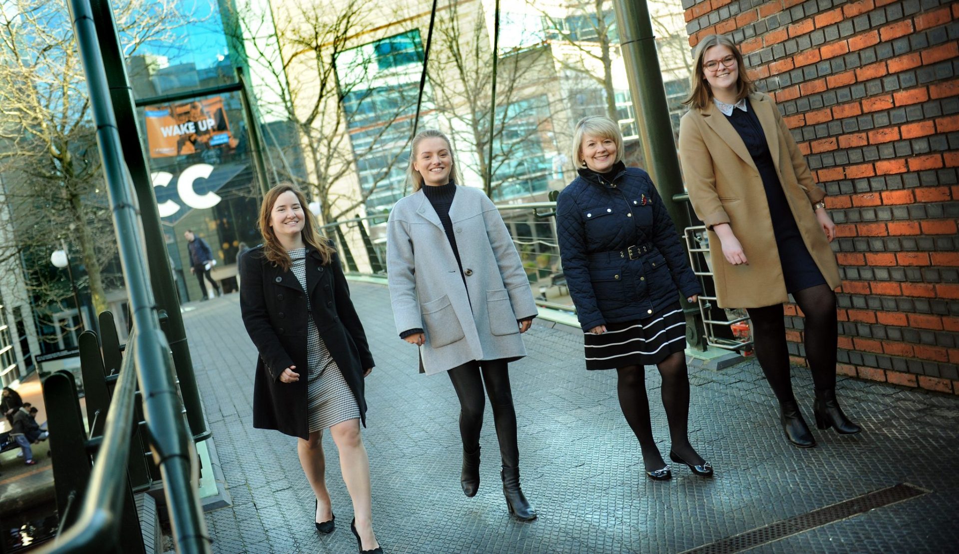 Four women walking over a bridge in Brindleyplace, Birmingham.