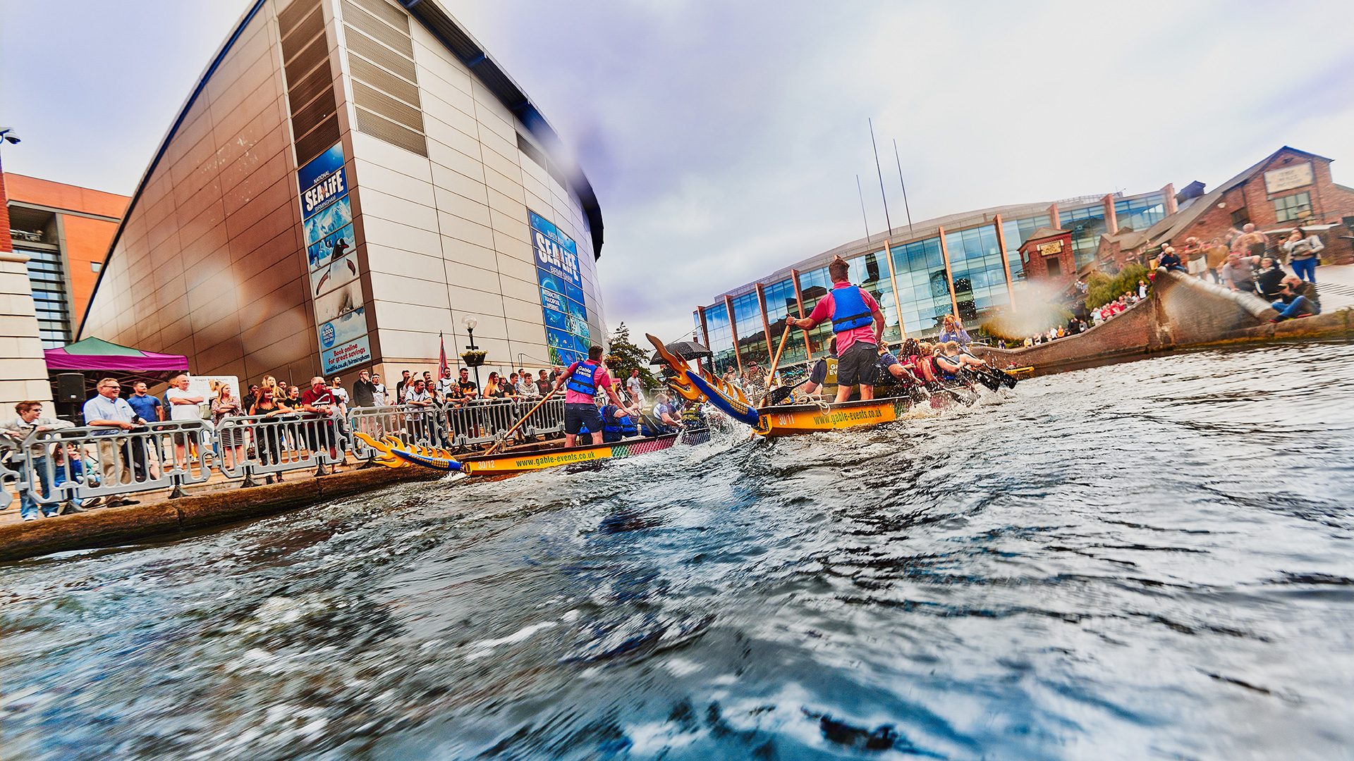 Rowing boats racing along the canal in Brindleyplace, Birmingham.