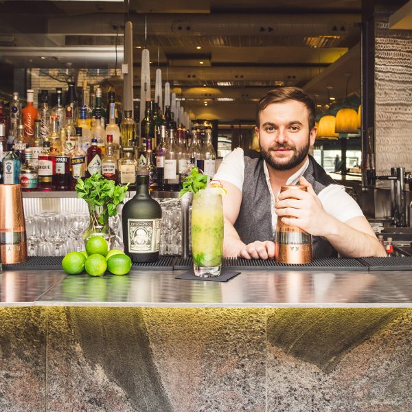 Man posing behind a bar with an attractive cocktail at Bank restaurant and bar in Birmingham.