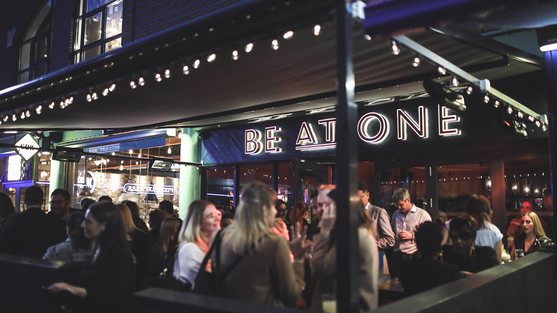 People enjoying themselves at night outside Be at One in Birmingham.