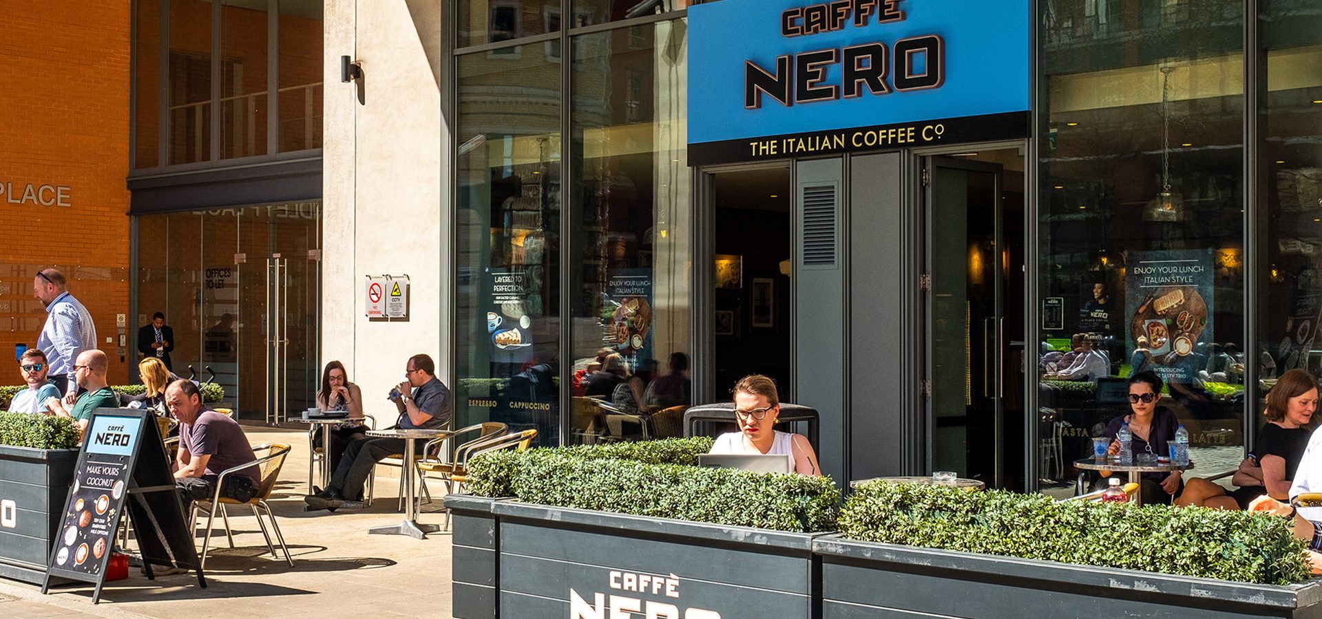 A handful of people sat outside Caffe Nero in Brindleyplace, Birmingham.