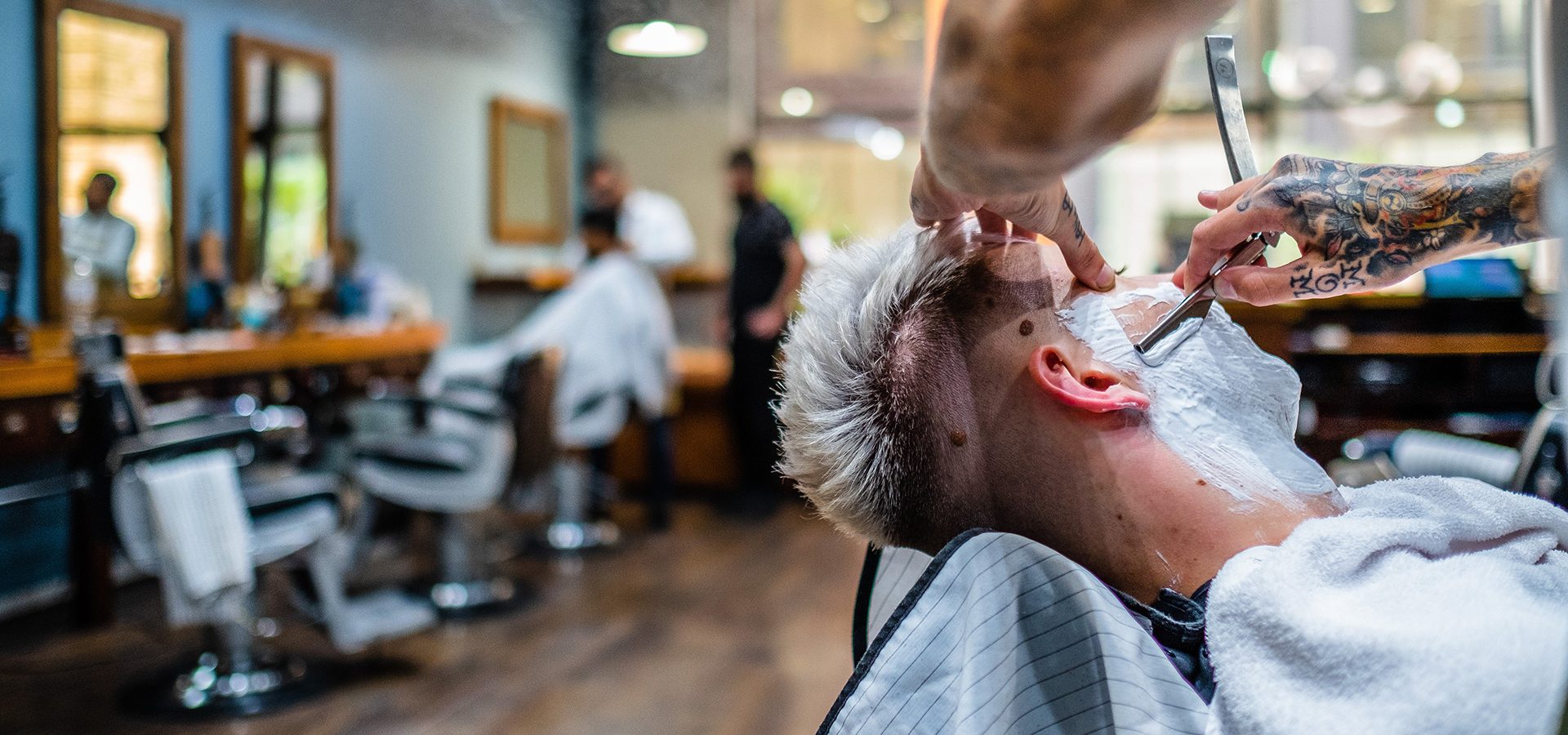 Man receiving a wet shave at Gentleman Barbers in Brindleyplace, Birmingham.
