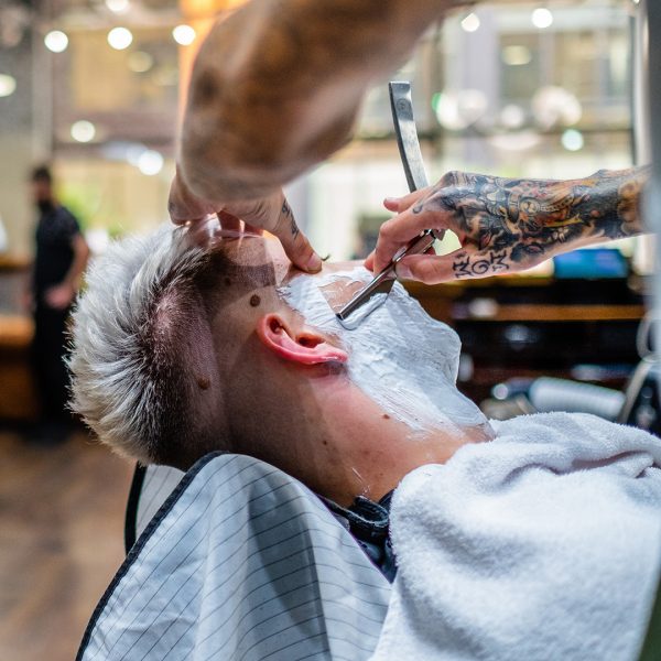 Man receiving a wet shave at Gentleman Barbers in Brindleyplace, Birmingham.