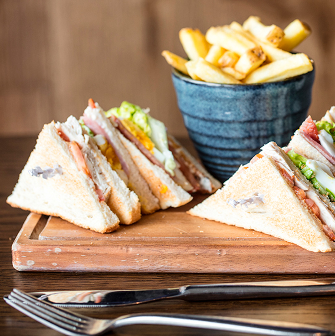 Sandwiches and chips on a wooden plate at Recess in Birmingham.
