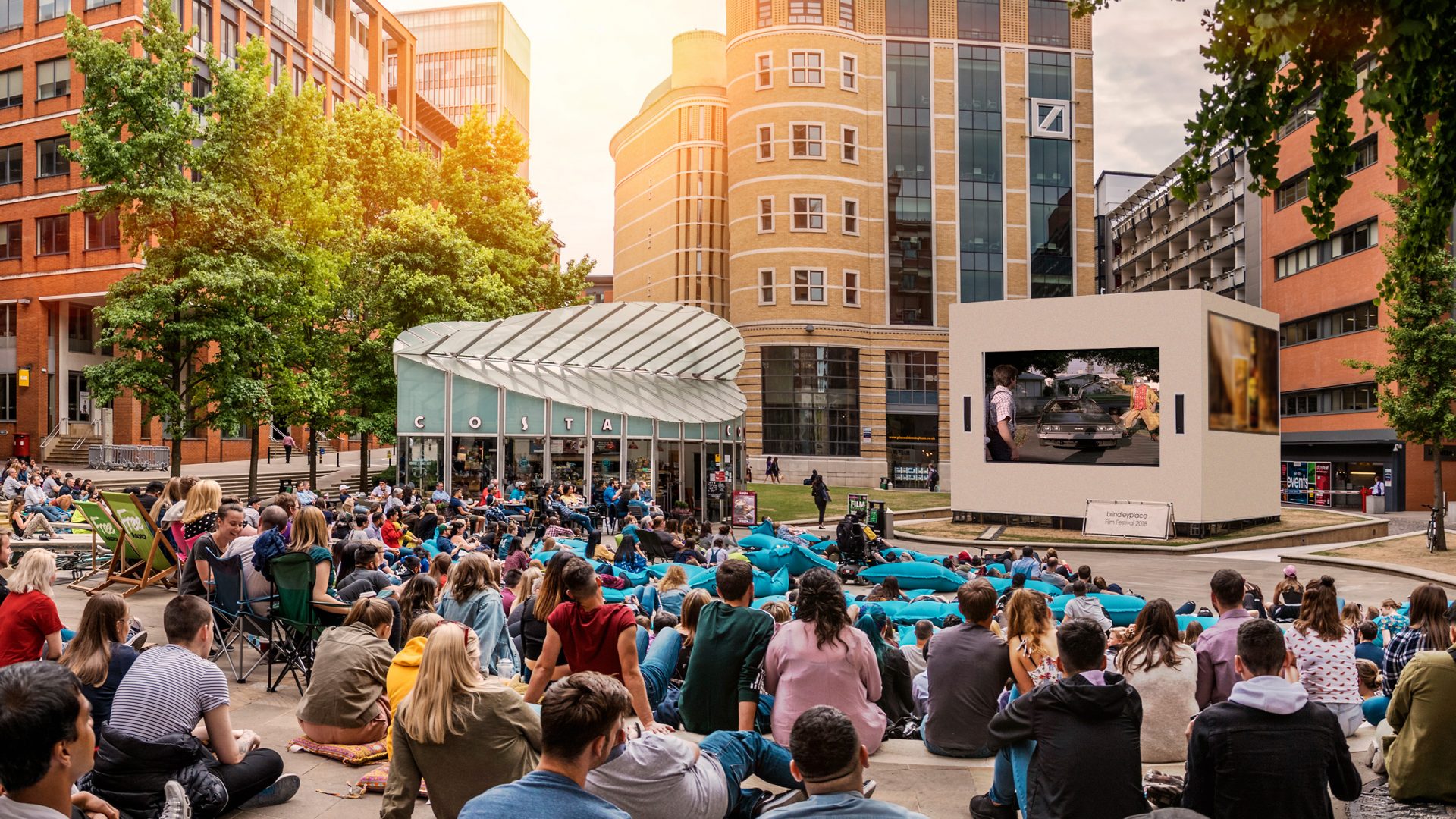 Large crowd at an outdoor cinema screening in Brindleyplace, Birmingham.