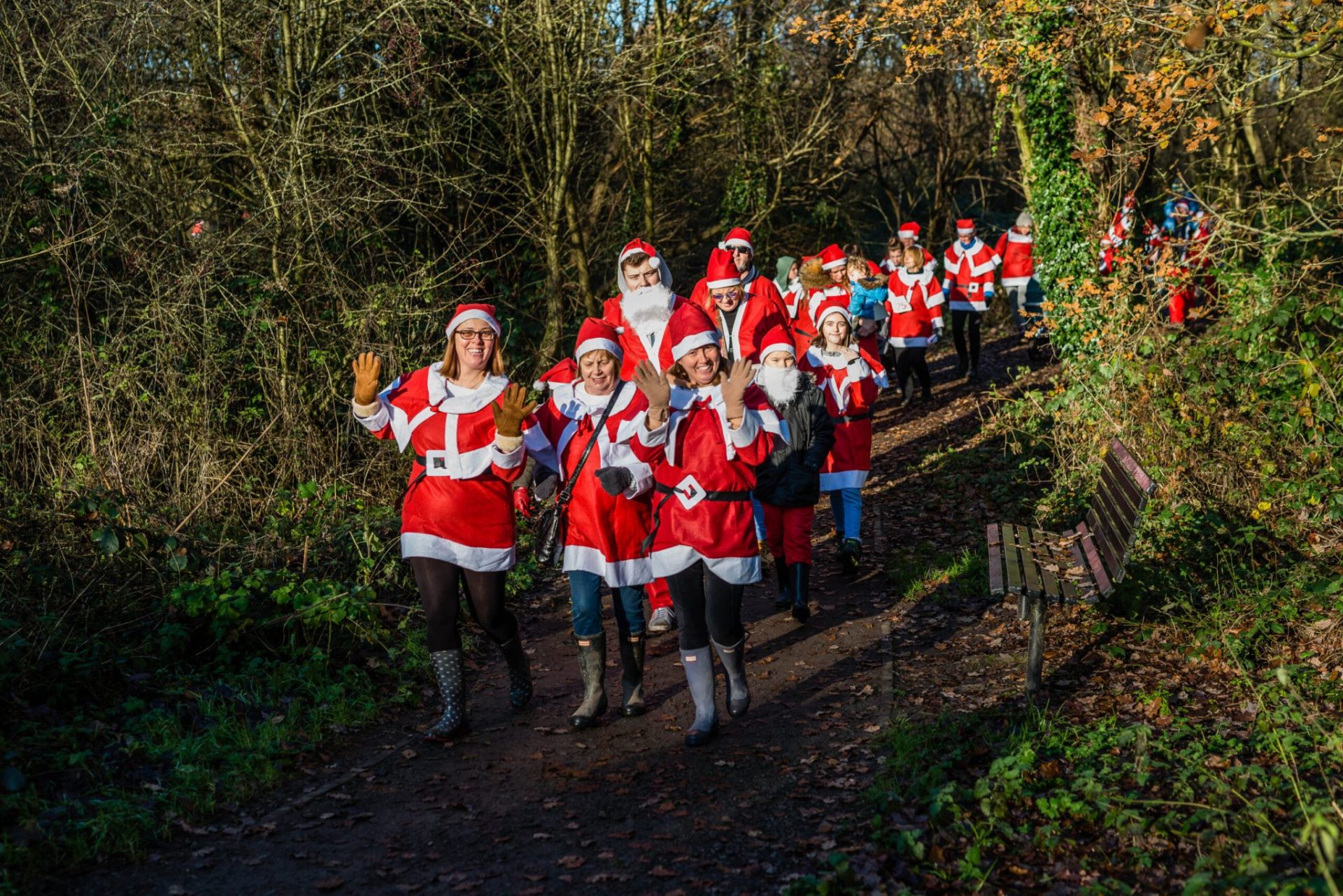 People in Santa suits doing a sponsored run for charity.